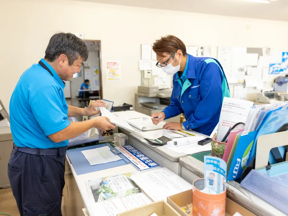 事務所で書類をやり取りするドライバー