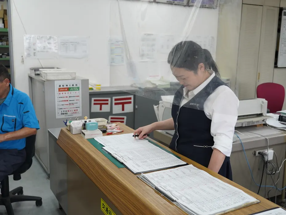 カウンターで書類を確認する事務社員